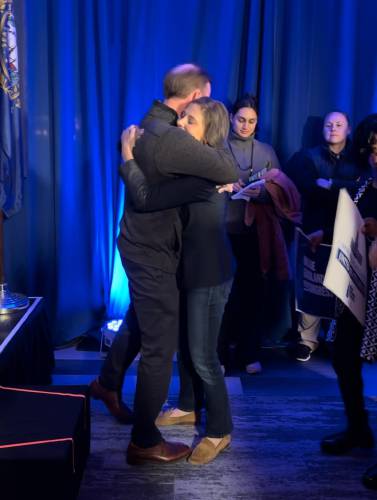 Maggie Goodlander hugs husband Jake Sullivan at election night event.