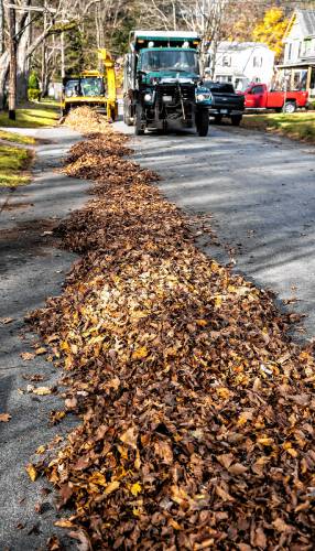 Leaves piled up on Coolidge Ave. in the South End of Concord wait to be picked up by the augur machine and blown into the backs of Concord dump trucks on Thursday, November 7, 2024.