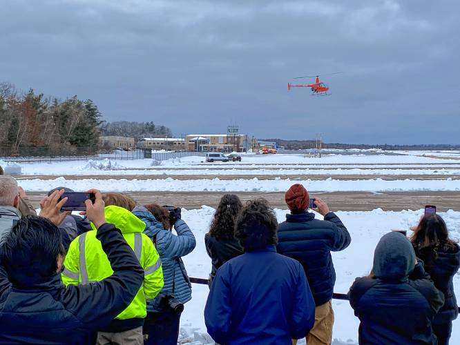 An autonomous helicopter being built by Rotor, flies during its first public demonstration, at Nashua Municipal Airport, where the company is based. The pilot is overseeing operations remotely from the white van parked on the ground. Jan. 30, 2024