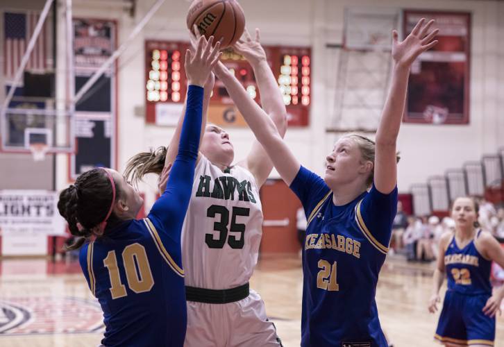 Kearsarge players Ava Shapiro (10), and Tessa Marinello (21) surround Hopkinton center Sydney Westover druing the Division III championship on Saturday night, February 24, 2024 at Keene State College.