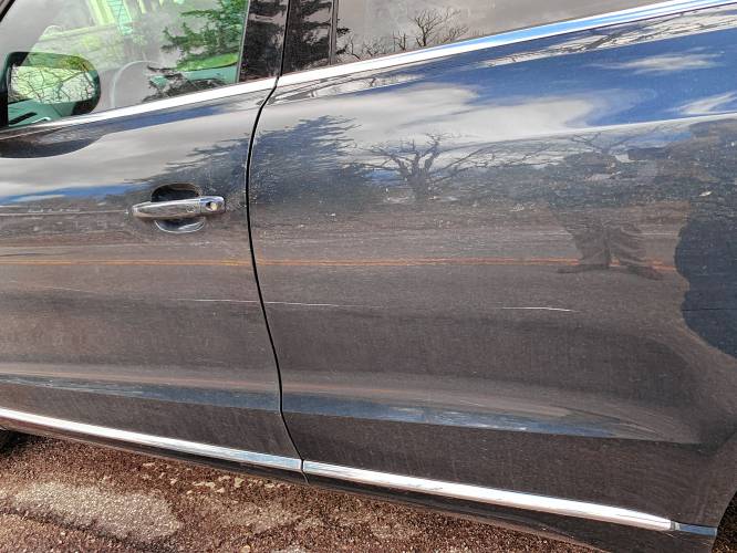 A party delegate from Claremont documents a key scratch on the driver’s side of his vehicle outside the NHGOP convention Saturday at Concord High.