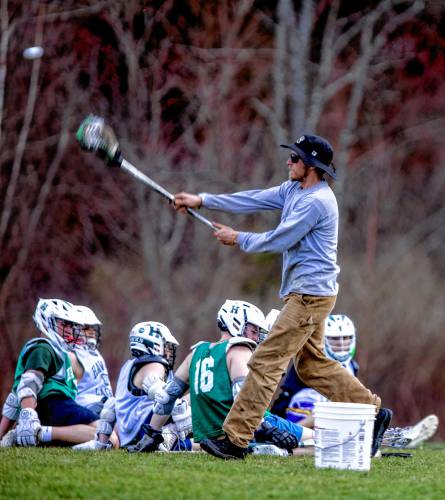 Hopkinton High boys’ lacrosse coach Deacon Blue throws a ball during a team practice last month. An organic farmer by trade, Blue sometimes employs methods used in his work to teach lacrosse to his athletes.