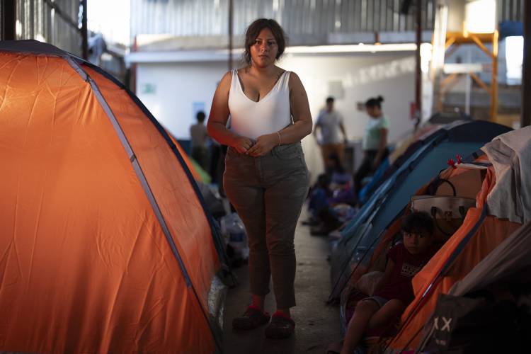 CORRECTS NAME TO ANDREA - Andrea, a migrant from southern Mexico, poses as others watch the presidential debate in a shelter for migrants waiting to apply for asylum, Thursday, June 27, 2024, in Tijuana, Mexico, as President Joe Biden and his Republican rival, Donald Trump, met for the first general election debate of the 2024 season. 