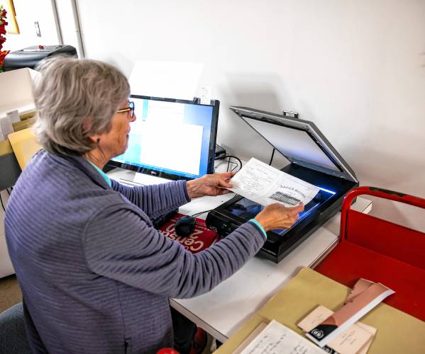 Concord Library volunteer Ginny Babczak prepares to scan in materials for the digital archive for the library. Babczak is a former librarian who comes in to scan materials. The archive goes up live on Dec. 9.