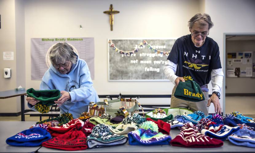 Suzie and Perry Seagroves unpack all the hats that Suzie has knitted lately at the Bishop Brady cafeteria on Feb. 19.