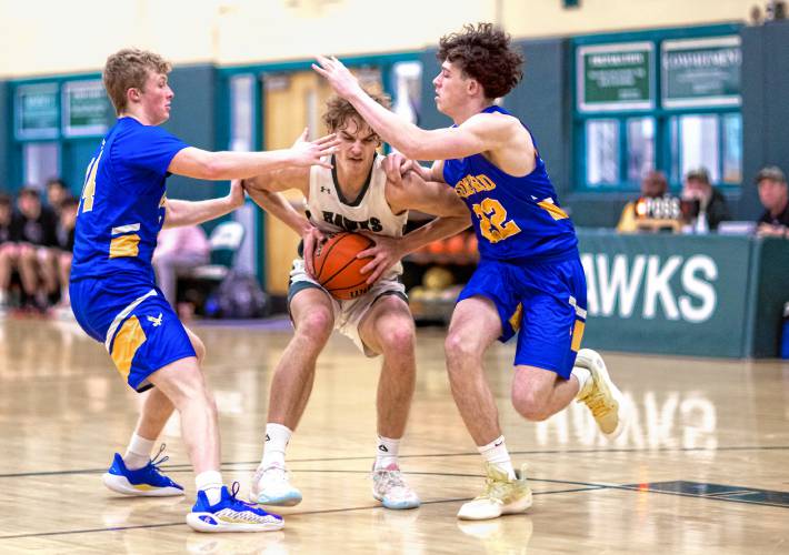 Gilford players surround Hopkinton center Abram Standefer during their matchup on January 17, 2024.