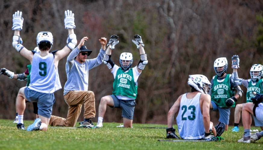 Hopkinton lacrosse coach Deacon Blue (second from left) leads his team in warmups during a practice last month.