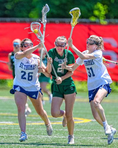 Hopkinton's Lily Chodosh tries to split through St. Thomas' Madison McMahon (26) and Julia Bryan (31) with the ball in her stick during the Division III girls' lacrosse semifinal on Saturday, June 1, 2024.