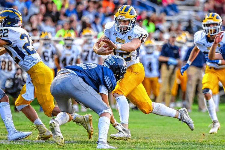 Bow senior quarterback Brady Lover (12) runs for a first down in a game against Merrimack Valley on Friday night. Lover moved the chains and showed his versatility through the air and on the ground for the Falcons in a 23-13 victory.