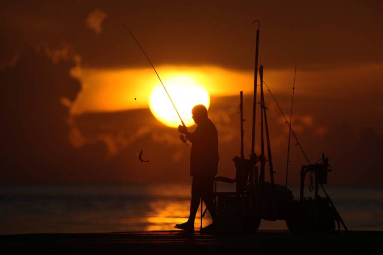 A fisherman reels in his catch as the sun rises over the Atlantic Ocean, June 28, 2023, in Bal Harbour, Fla. An already warming Earth steamed to its hottest June on record, with global oceans setting temperature records for the third straight month, the U.S. National Oceanic and Atmospheric Administration announced. A fisherman reels in his catch as the sun rises over the Atlantic Ocean, June 28, 2023, in Bal Harbour, Fla. An already warming Earth steamed to its hottest June on record, with global oceans setting temperature records for the third straight month, the U.S. National Oceanic and Atmospheric Administration announced.