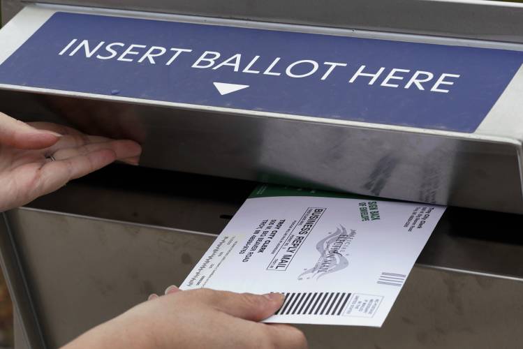 A Michigan voter inserts her absentee voter ballot into a drop box in Troy, Mich. on Oct. 15, 2020. A Michigan voter inserts her absentee voter ballot into a drop box in Troy, Mich. on Oct. 15, 2020.
