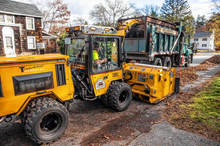Leaves are swept up by the augur machine and blown into the backs of Concord dump trucks on Thursday, November 7, 2024.
