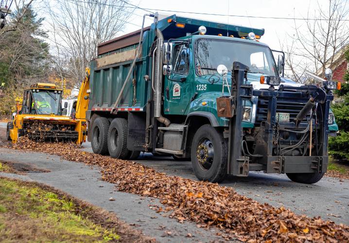 Leaves piled up on Coolidge Ave. in the South End of Concord wait to be picked up by the augur machine and blown into the backs of Concord dump trucks on Thursday, November 7, 2024.