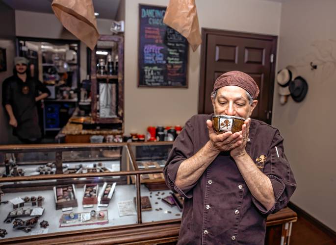 Richard Tango-Lowy, owner of Dancing Lion Chocolate, takes a sniff of his Olmec Drinking Chocolate at his store on Elm Street in Manchester on Wednesday, October 30. 2024. Luxury Travel Guide named Dancing Lion Chocolate the 2024 Top Confectionery Store in the world.