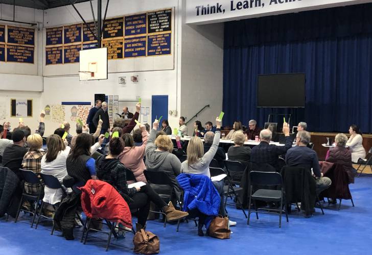 Deerfield residents raise their placards at the 2023 deliberative session held at Deerfield Community School on Feb. 11, 2023.