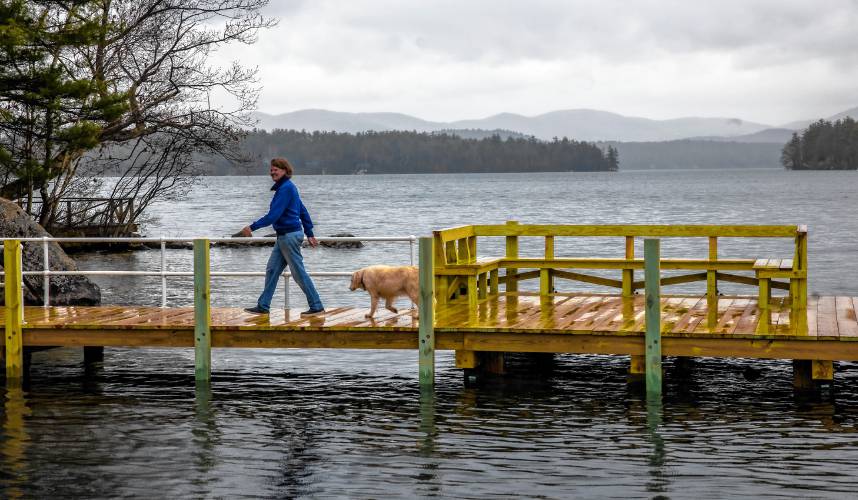 Laura Prichard walks on the new dock on the shore of the Keewaydin area of Lake Winnipesaukee. The former lake community dock was destroyed in a boat accident last year.