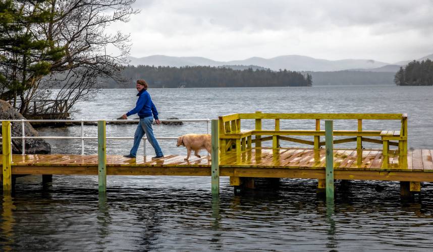 Laura Prichard walks on the new dock on the shore of the Keewaydin area of Lake Winnipasaukee. The former lake community dock was destroyed in a boat accident last year.