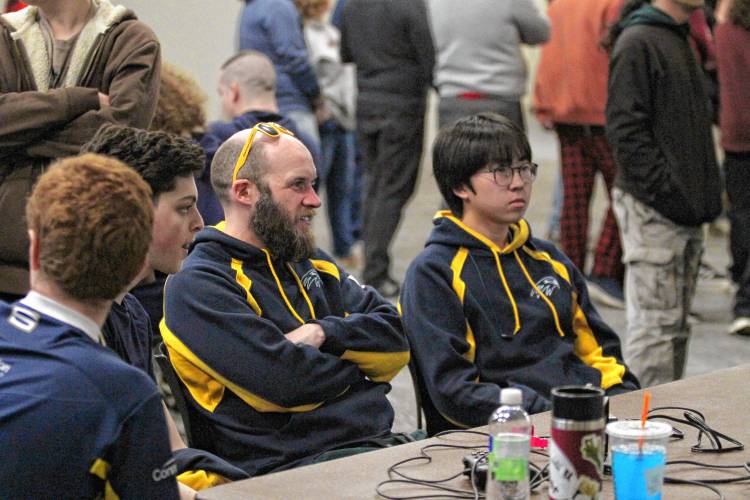 (L to R) Junior Matthew Kropp, coach Allan Sheehy and Noi Araya prepare for their next bracket match-up and study strategy during the Super Smash Bros. State Championship.