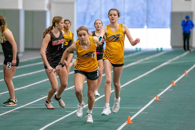 Bow’s Hannah Pawlowski (front center) receives the baton from teammate Camden Wilson during the 4x200-meter relay race at an indoor track meet on Saturday at Plymouth State. Bow won the relay and the team title at the 18-team meet.