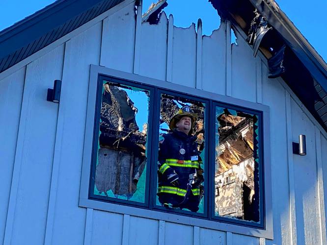 Dublin Firefighter Mark Munroe inspects damage to the home on Cranberry Meadow Drive Tuesday morning.