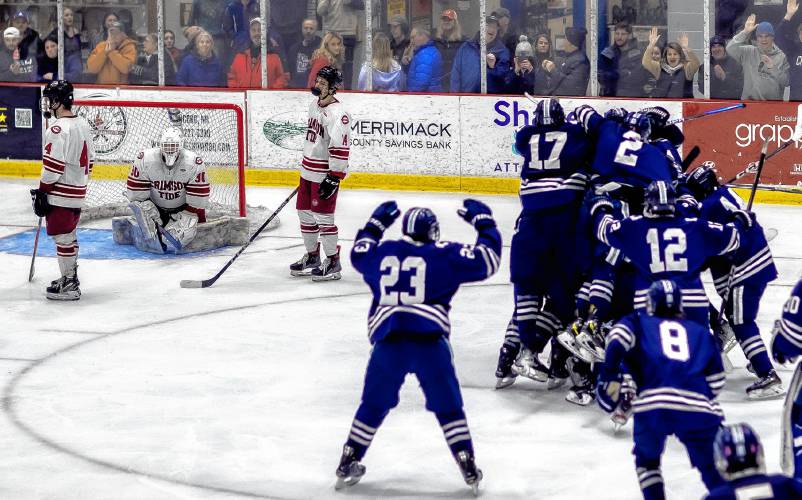 The Exeter hockey team gathers to celebrate after scoring the game-winning goal in 4-3 overtime victory in the Division I quarterfinals at Everett Arena on Saturday night.