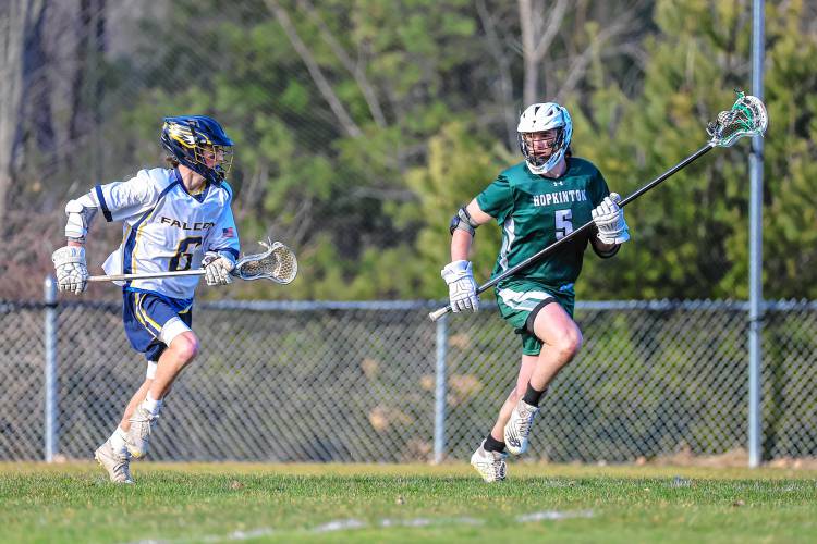 Hopkinton captain Cam Bassett looks to move the ball downfield in the Hawks’ season-opening win over Bow on April 9.