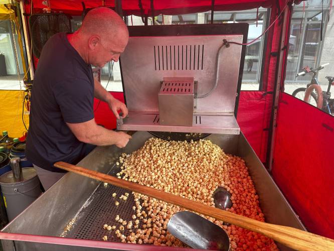 John DuPont prepares kettle corn at a street fair in Concord, N.H., on Thursday morning, June 20, 2024, where the temperature was near 90 degrees. (AP Photo/Kathy McCormack)