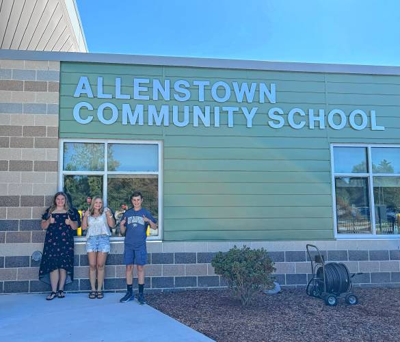 Eighth grade students Brielle (left), Morgan (center) and Grady (right) in front of Allenstown Community School.