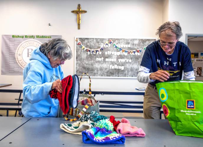 Suzie and Perry Seagroves unpack hats that Suzie knitted recently at the Bishop Brady cafeteria on February 19, 2025.