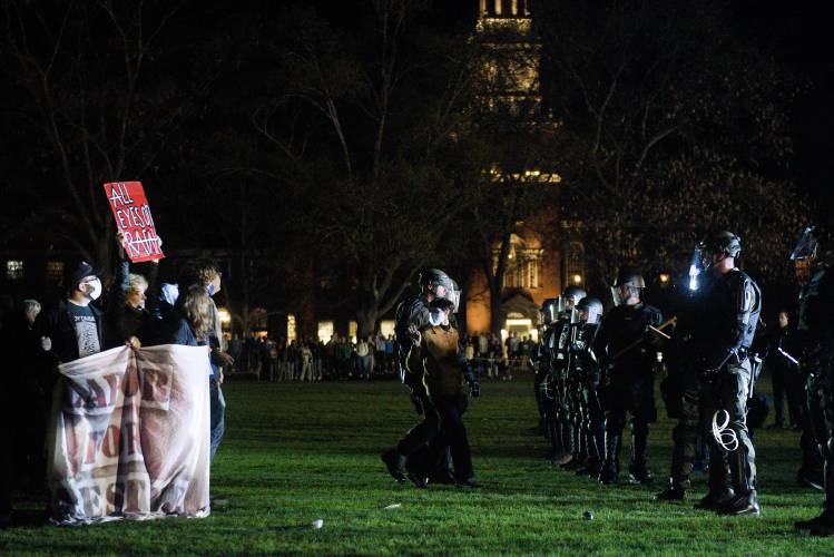 A protester waves to friends while being arrested by New Hampshire State Police on the Dartmouth College Green in Hanover, N.H., on Wednesday, May 1, 2024. Students protesting the Israel-Hamas War and demanding Dartmouth College divest from companies connected to Israel, set up an encampment on in defiance of university policies. (Valley News - James M. Patterson) Copyright Valley News. May not be reprinted or used online without permission. Send requests to permission@vnews.com.