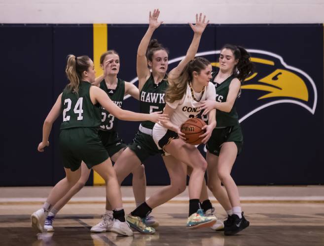 Four Hopkinton players collapse to defend against Conant forward Emma Tenters during the first half of last season’s Division III semifinal at Bow High School on Feb. 24. The Hawks will be led by new head coach Mike Mahoney in the 2023-24 season.