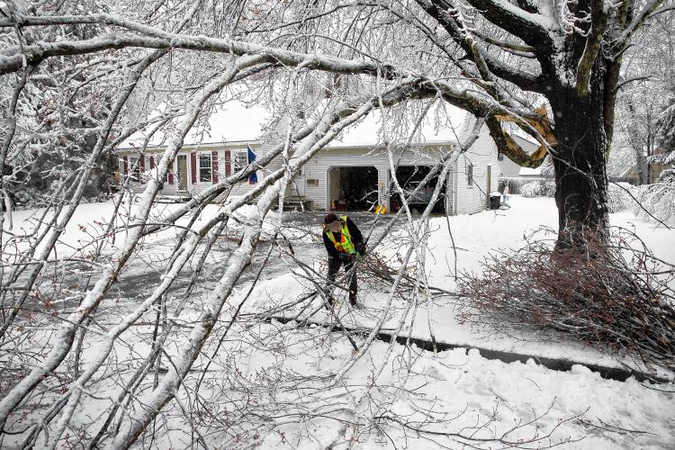 Marty Walsh cuts up  a  branch that fell down in front of his home on Middlebury Street in the South End of Concord on Thursday, April 4, 2024. Walsh did not lose power but got out and cut the branches so cars could get through.