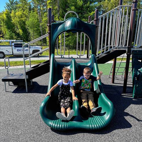 First grade students Charlotte (left) and Jackson exploring the new playground of Allenstown Community School.