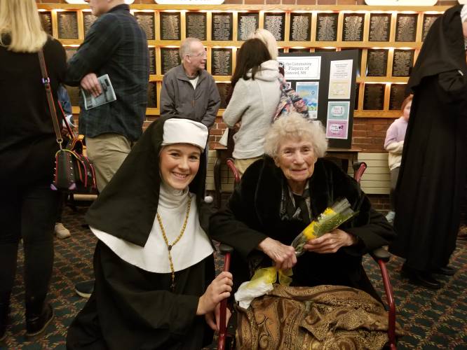 Local teacher Hannah McCauley, playing “Sister Sophia,” hands flowers to Clara Lemm Brogan, who played the role of “Sister Sophia” on the same stage during a 1966 production of “The Sound of Music.”