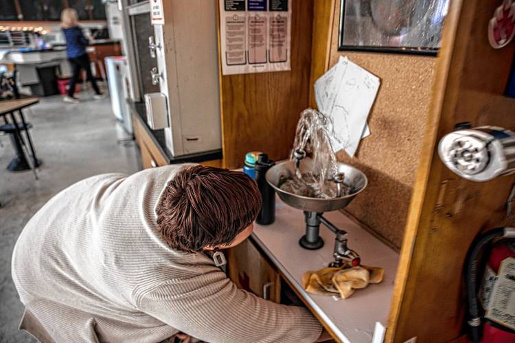 Rundlett science teacher Michelle Ruopp has to use the lower turn-off valve to shut off the eyewash station in her classroom on Monday.