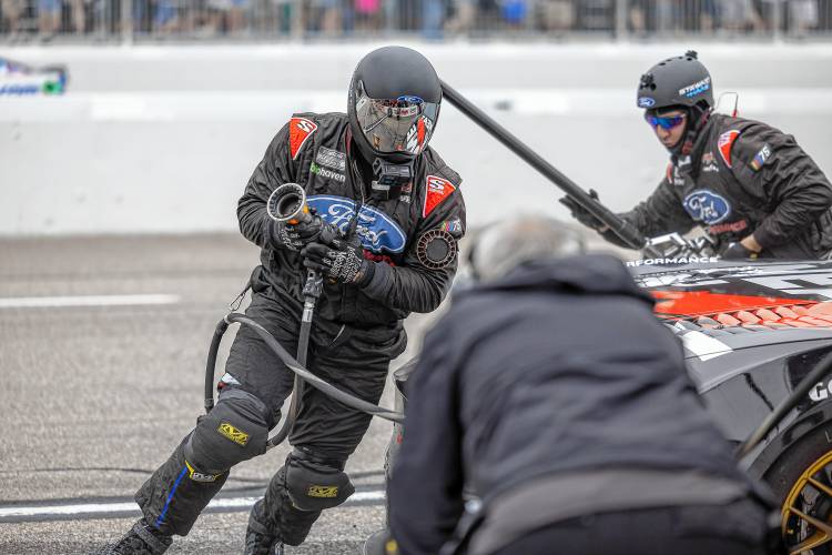 The pit crew for NASCAR Cup Series driver Kaz Grala gets to work during a mid-race pit stop on Sunday.