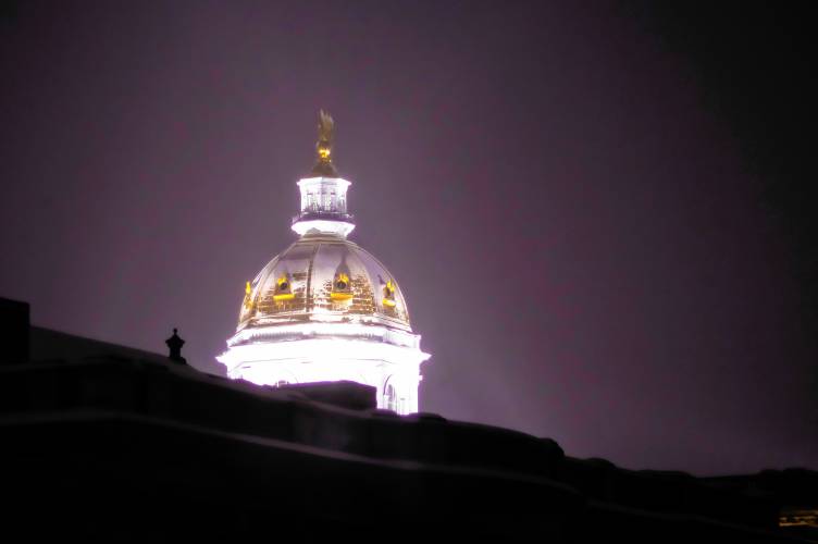 The State House dome is covered in snow from the latest storm just before dawn on Thursday, February 13. 2025.