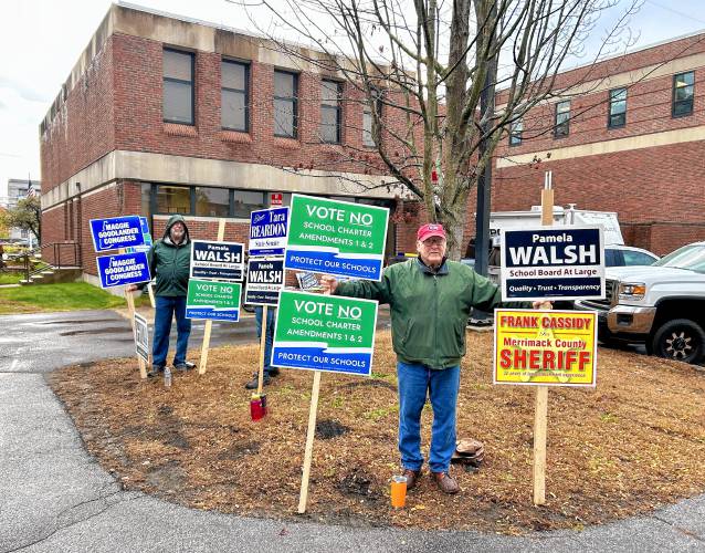 Tom Croteau, who is running for Concord School Board treasurer, holds a sign outside of Concord's Ward Four polling location at the Green Street Community Center. 