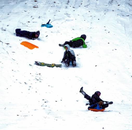 The snow hill at White Park was popular during the Sunday snowstorm for sledders and parents.