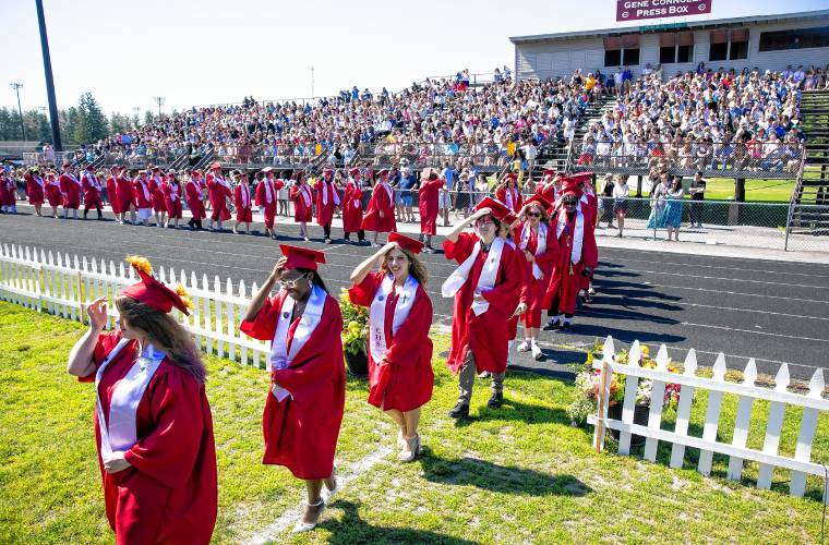 Concord High School graduates have to hold on to their caps as a strong gust of wind blew through Memorial Field as they entered to receive their diplomas on Saturday, June 15, 2024.