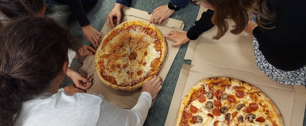 Reporters use string to measure the circumference of a Market Basket pizza only to realize it wasn’t a perfect circle. The popular supermarket chain offers 19-inch pizzas served in 18-inch boxes.
