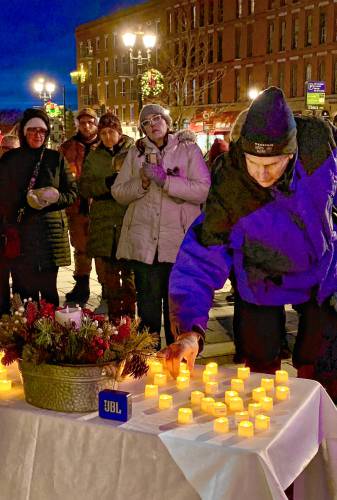 Ignatius MacLellan of New Hampshire Housing places a candle for one of the 54 homeless individuals who lost their lives in 2024 at the vigil at City Plaza on Thursday evening, December 19, 2024. Homelessness rose by 52 % in New Hampshire from 2022 to 2023, faster than in any other state, according to the 2023 Annual Homelessness Assessment Report.
