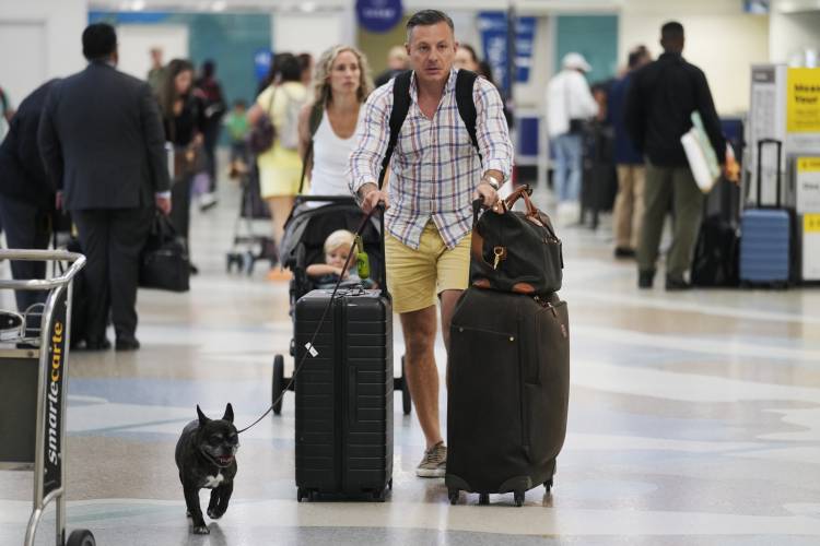 Travelers rush to check in their bags at Fort Lauderdale- Hollywood International Airport, Tuesday, Nov. 21, 2023, in Fort Lauderdale, Fla. Millions of people are expected to hit airports and highways in record numbers over the Thanksgiving holiday. (AP Photo/Marta Lavandier).