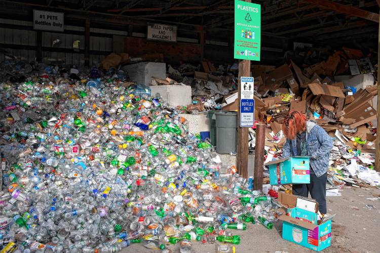 Sarah Kelley of Hopkinton separates plastic materials into the recycling pile at the Hopkinton Webster Transfer Station in Hopkinton on Wednesday, January 3, 2024.