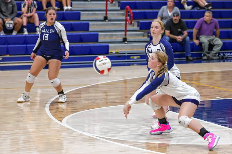 Merrimack Valley’s Aubrie Austin (4) digs a serve as teammates Ryleigh Perry (2) and Taliyah Chudoba (13) watch on. MV lost to Kingswood in its first ever home varsity volleyball match, 25-10, 25-14, 25-9, on Friday.