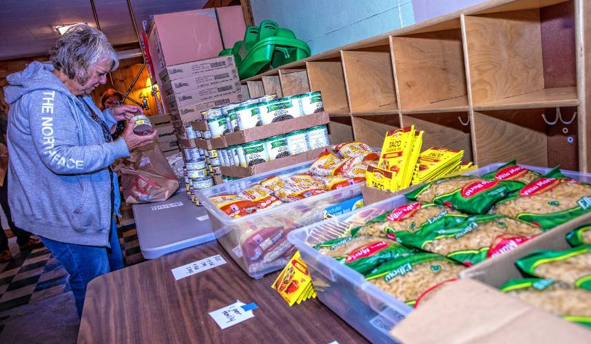 Volunteer Darlene Batza puts food into bags for distribution at the food bank located in the basement of the Early Head Start building in Pittsfield on Thursday, Sept. 26.