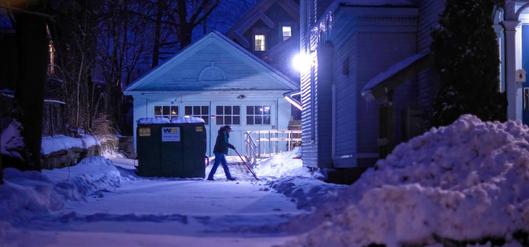 A person plows a driveway in the driveway of a building on Court Street near dawn on Thursday, February 13, 2025. Another bigger storm is set to hit this weekend.