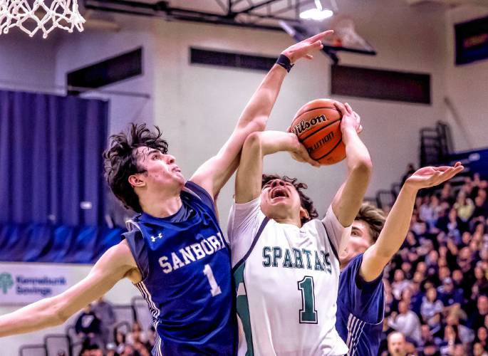 Pembroke guard Evan Berkeley (center) gets fouled by Sanborn forward Chase Frizzell on Sunday at UNH.