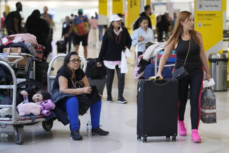 Passengers wait to check in at Fort Lauderdale- Hollywood International Airport, Tuesday, Nov. 21, 2023, in Fort Lauderdale, Fla. Millions of people are expected to hit airports and highways in record numbers over the Thanksgiving holiday. (AP Photo/Marta Lavandier).