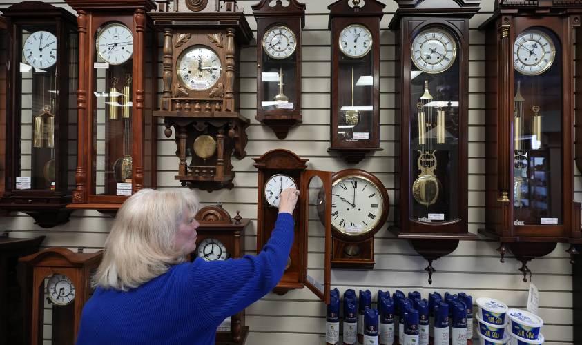 Glenda Marchesoni, owner of Heritage House Clocks, winds a clock at her shop Tuesday, March 5, 2024, in Farmers Branch, Texas. Once again, most Americans will set their clocks forward by one hour this weekend, losing perhaps a bit of sleep but gaining more glorious sunlight in the evenings as the days warm into summer. (AP Photo/LM Otero)